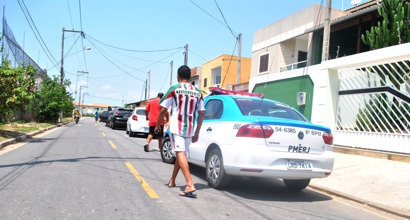 A vítima, de costas e usando camisa do Fluminense, deixa sua casa para prestar queixa na 134ª DP/Centro (Foto: Filipe Lemos/ Campos 24 Horas)