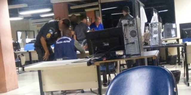 Suspeito, de camisa azul, aguarda para ser interrogado na 134ªDP