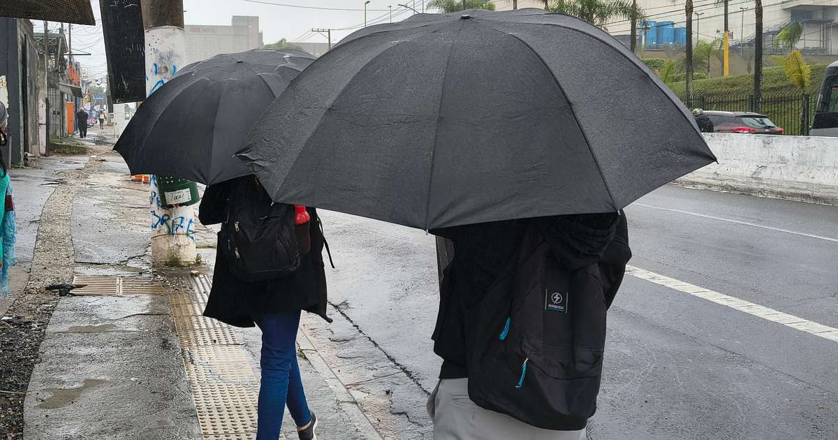 Pedestres se protegem da chuva em São Paulo